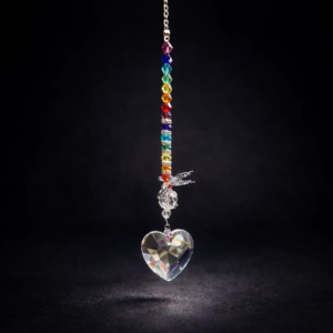 Handmade rainbow crystal heart suncatcher with colorful glass beads and butterfly charm on a dark elegant background.