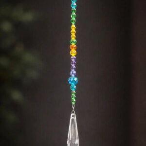 Rainbow crystal prism drop suncatcher with colorful glass beads and long faceted crystal prism hanging on dark background.