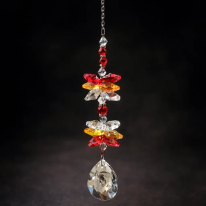 Handmade sunset crystal suncatcher with red, amber, and clear glass beads and prism crystal on dark background